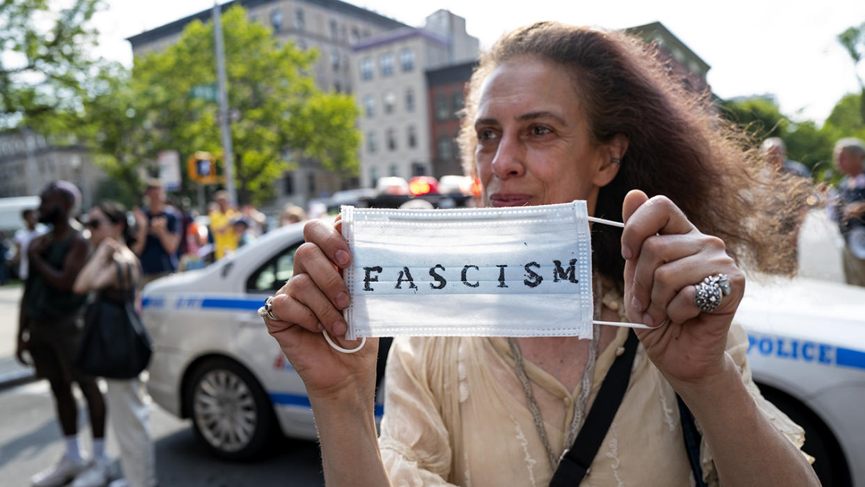 An activist holds a surgical mask during a protest of a visit by first lady Jill Biden and Dr. Anthony Fauci, director of the National Institute of Allergy and Infectious Diseases, at a nearby vaccine clinic at the Abyssinian Baptist Church in the Harlem neighborhood of New York, Sunday, June 6, 2021. (Craig Ruttle/AP)