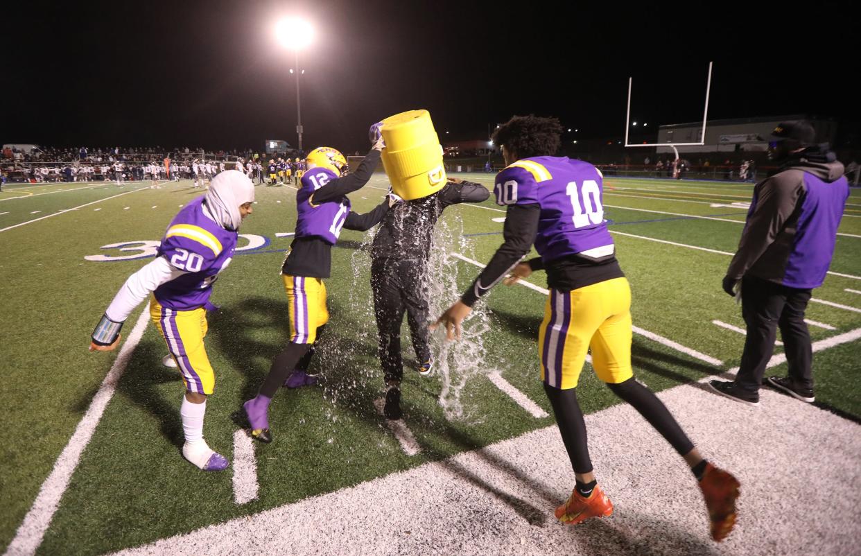 Kelvin Shepard, Ricardo Carrero Chico and Charles Garcia dump water on one of their head coaches, James Vann in the final minute of their Section V Class A championship game against Brighton at Fairport High. East/WOIS won 23-8..