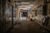 <p>Abandoned corridor with lockers. Some look vandalized, others look like they’ve been abandoned for only a few days rather than 10 years. (Photo: Leland Kent/Caters News) </p>
