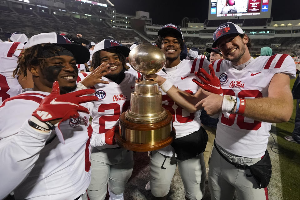 Mississippi players celebrate their win over Mississippi State and their retaining of the "Golden Egg" trophy following an NCAA college football game against Mississippi State, Thursday, Nov. 25, 2021, in Starkville, Miss. (AP Photo/Rogelio V. Solis)