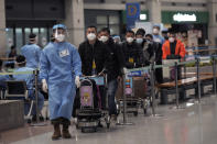 Passengers arriving from China are escorted by a South Korean army soldier to proceed to a COVID-19 testing center at the Incheon International Airport in Incheon, South Korea on Jan. 14, 2023. A hoped-for boom in Chinese tourism in Asia over next week’s Lunar New Year holidays looks set to be more of a blip as most travelers opt to stay inside China if they go anywhere. (AP Photo/Ahn Young-joon)