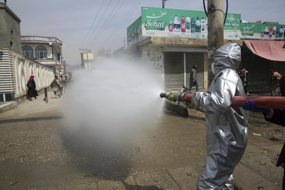 Volunteers and municipality workers in protective suits spray disinfectant along a street to help curb the spread of the coronavirus in Kabul, Afghanistan, Wednesday, April 8, 2020. The new coronavirus causes mild or moderate symptoms for most people, but for some, especially older adults and people with existing health problems, it can cause more severe illness or death. (AP Photo/Rahmat Gul)