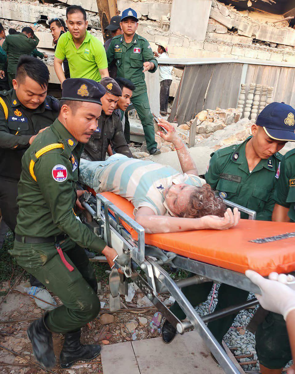 Photo provided by the Kep Province Authority Police, emergency workers carry a survivor from the debris after a building collapsed in Kep province, Cambodia, Friday, Jan. 3, 2020. At least two construction workers were killed when a seven-floor building collapsed in the southern Cambodian town of Kep on Friday, according to the police. (Kep province Authority Police via AP)