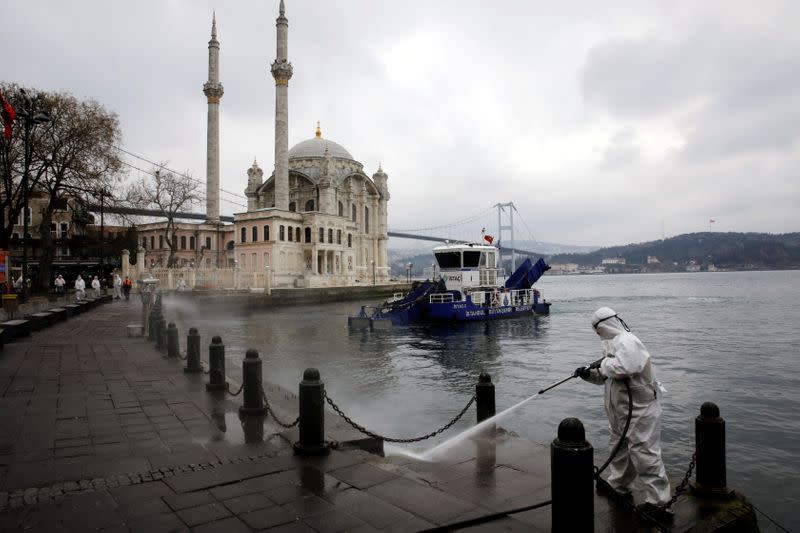 FILE PHOTO: A worker sprays disinfectant outside Ortakoy Mosque, to prevent the spread of coronavirus disease (COVID-19), in Istanbul