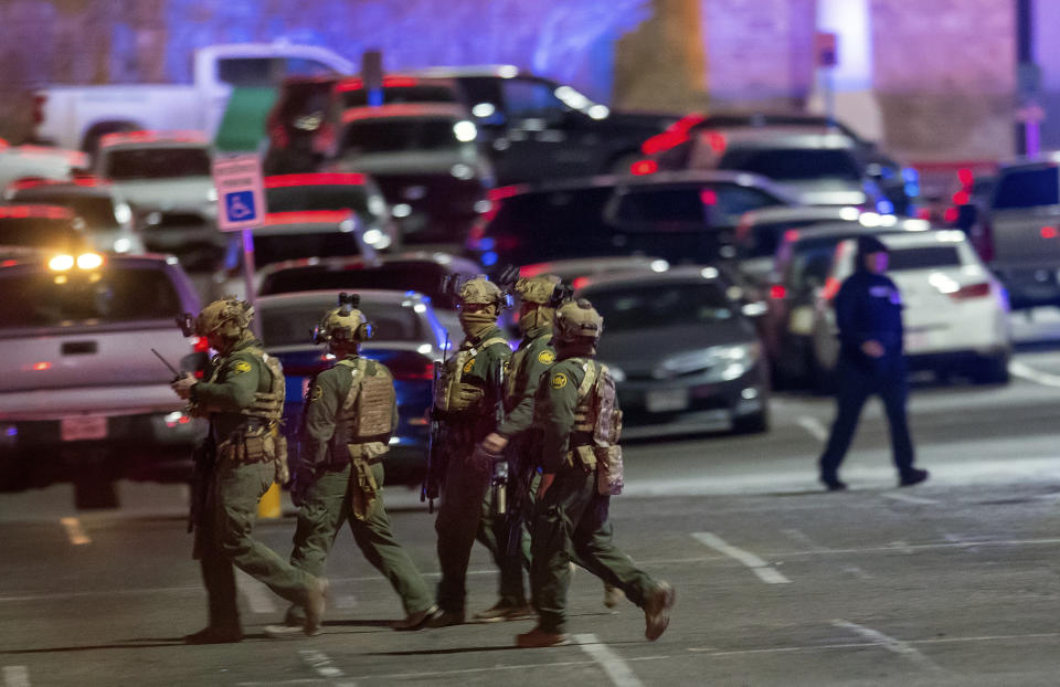 Law enforcement agents walk in the parking lot of a shopping mall, Wednesday, Feb. 15, 2023, in El Paso, Texas. Police say one person was killed and three other people were wounded in a shooting at Cielo Vista Mall. One person has been taken into custody, El Paso police spokesperson Sgt. Robert Gomez said. (AP Photo/Andrés Leighton)