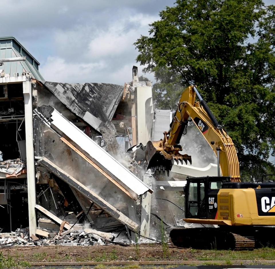 A Macon-Bibb County excavator begins the tear down of the former Greater Chamber of Commerce building Wednesday morning at 305 Coliseum Drive. The removal of the building will increase parking for the Macon Coliseum.