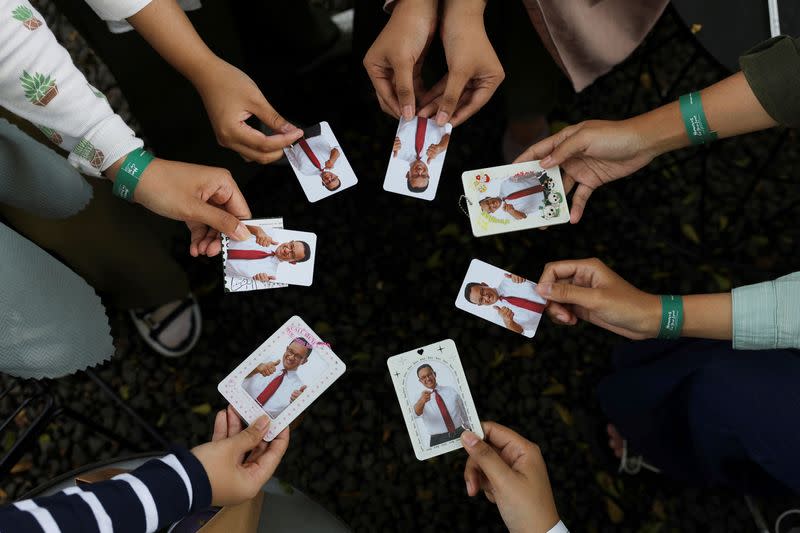 People show photocards during the Humanies Cup Sleeve Event at the Kopi Nako cafe in Jakarta