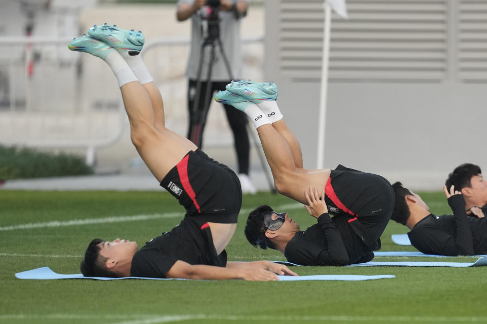 South Korea's Son Heung-min, right, warms up during a training session at Al Egla Training Site 5 in Doha, Qatar, Wednesday, Nov. 30, 2022. South Korea will play its third match in Group H in the World Cup against Portugal on Dec. 2. (AP Photo/Lee Jin-man)