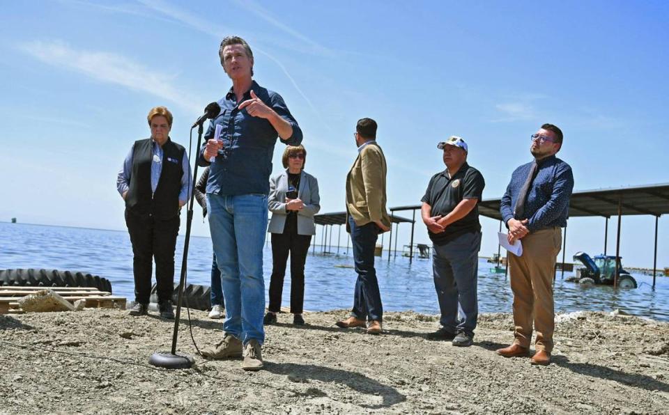 California Governor Gavin Newsom, second from left, speaks at Hansen Ranches in an area surrounded by flooded land along 6th Avenue Tuesday afternoon, April 25, 2023 just south of Corcoran, CA.