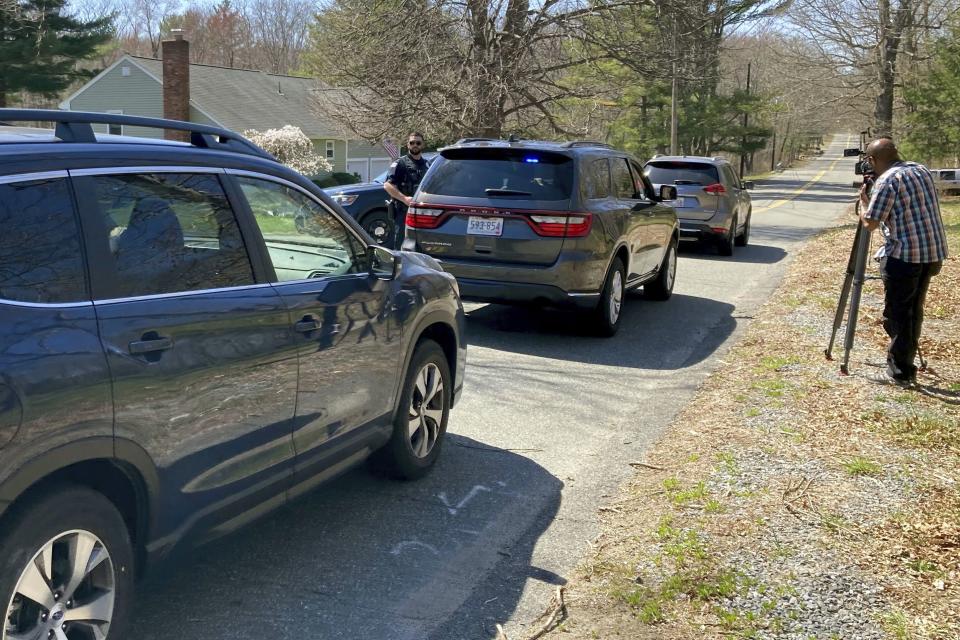 Vehicles move through a police blockade on a road in North Dighton, Mass., Thursday, April 13, 2023. The FBI wants to question a 21-year-old member of the Massachusetts Air National Guard in connection with the disclosure of highly classified military documents on the Ukraine war, two people familiar with the investigation said. (AP Photo/Michelle R. Smith)