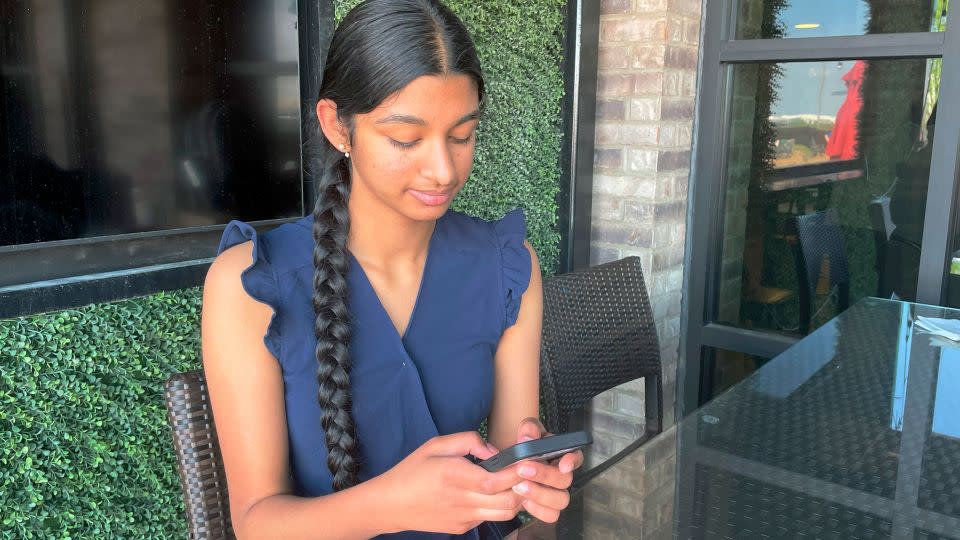 Shreya Nallamothu looks at her phone in May 2023 in Bloomington, Illinois. The teenager was instrumental in persuading Illinois lawmakers to pass a law creating protections for child social media influencers. - Claire Savage/AP