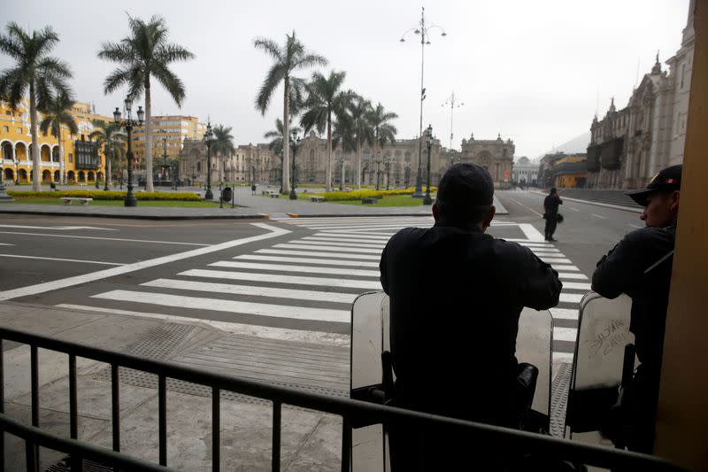 Police officers guard an empty Plaza de Armas after Peru's government deployed military personnel to block major roads, as the country rolled out a 15-day state of emergency to slow the spread of coronavirus disease (COVID-19), in Lima