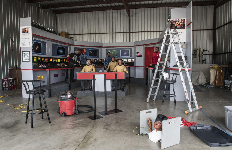 In this Saturday, March 25, 2017 photo, Steve Greenthal, left, and Chris Liebl work to set up their Star Trek wax figures in a hangar at the Fullerton Airport before donating them to the Hollywood Science Fiction Museum, in Fullerton, Calif. The figures are being restored for a five-year tour to raise money to get the museum a permanent home. (Nick Agro /The Orange County Register via AP)