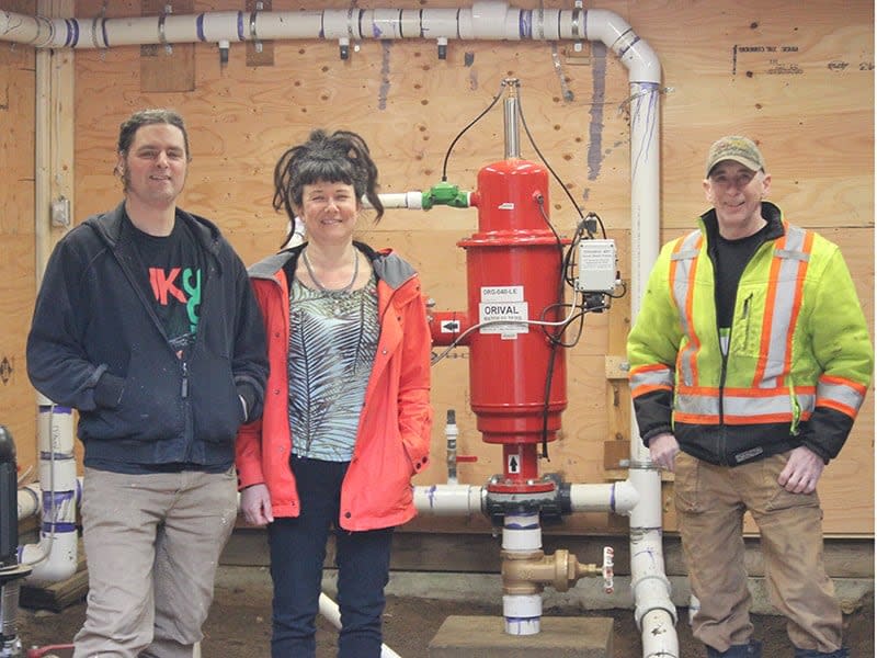Tyler and Melanie Pantalone, at left, thought they could help the community when they purchased Lang Bay Waterworks. But they found the utility's infrastructure was in need of serious repair. They're pictured with excavator operator Bernard Sattmann.  (Melanie Pantalone - image credit)