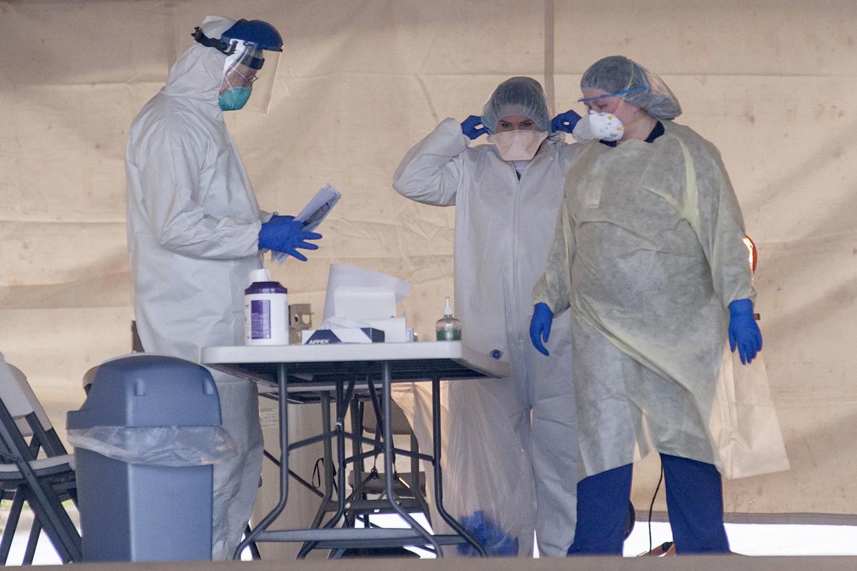 Healthcare professionals wear personal coronavirus from their parked cars on Tuesday, March 24, 2020, at the St. Bernards Urgent Care Clinic on Red Wolf Boulevard in Jonesboro, Ark. (Quentin Winstine/The Jonesboro Sun via AP)