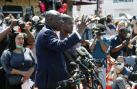 Quincy Mason, son of George Floyd, listens Wednesday, June 3, 2020 as family attorney Ben Crump, left, addresses a news conference as they and some Floyd family members visit the site in Minneapolis. Floyd, a black man died after being restrained by Minneapolis police officers on May 25 .(AP Photo/Jim Mone)