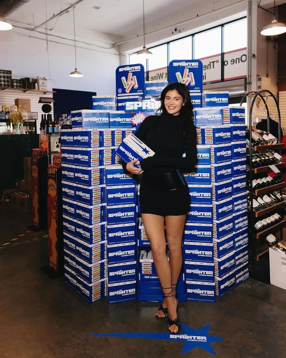 a woman standing in front of a stack of books