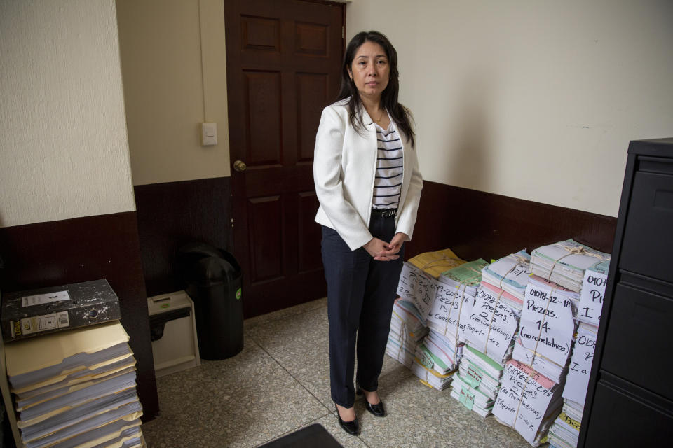 In this Nov. 8, 2019 photo, Guatemalan judge for high risk crimes Erika Aifan poses for photos at her office in Guatemala City. Aifan speaks softly and uses her words sparingly, appearing shy. But her rulings have been blunt, sometimes threatening the powerful and sending politicians and businesspeople to prison. (AP Photo/Moises Castillo)