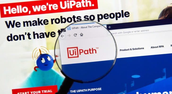 A magnifying glass zooms in on the website homepage of UiPath (<a class=