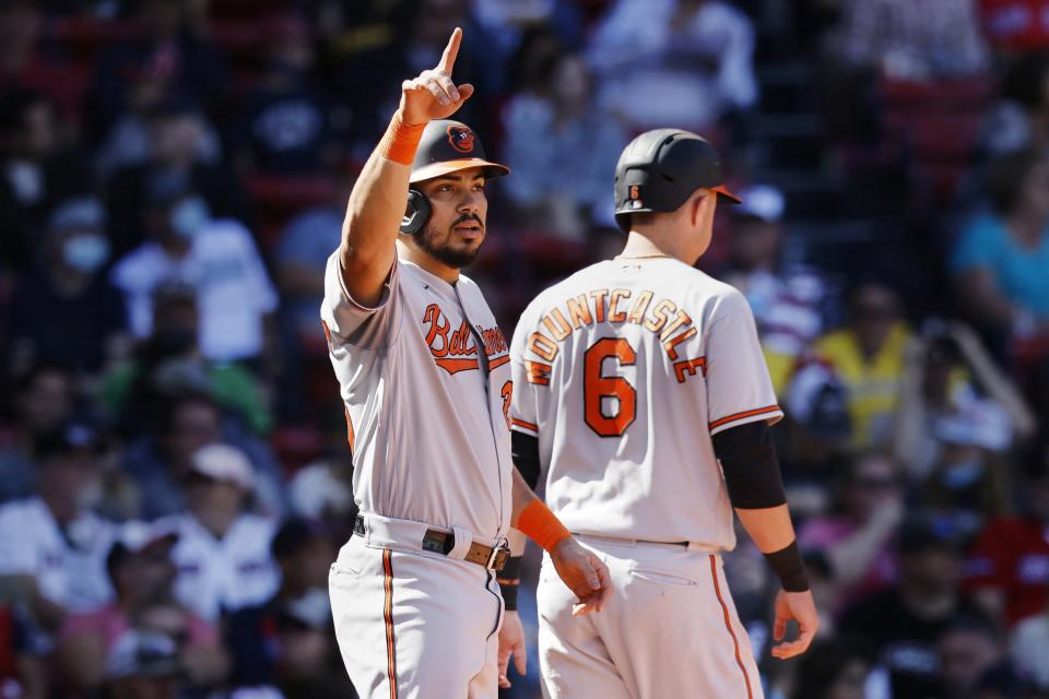 Baltimore Orioles' Anthony Santander signals after scoring with Ryan Mountcastle (6) on a single by Austin Hays during the third inning of a baseball game against the Boston Red Sox, Sunday, Sept. 19, 2021, in Boston. (AP Photo/Michael Dwyer)