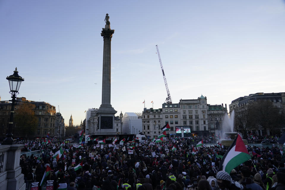Protester hold flags and placards as they take part in a pro-Palestinian demonstration in Trafalgar Square in London, Saturday, Nov. 25, 2023. (AP Photo/Alberto Pezzali)
