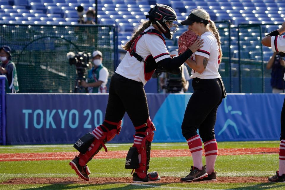 Team Canada catcher Kaleigh Rafter, left, talks with pitcher Danielle Lawrie, right, during a softball game against Japan on July 25.