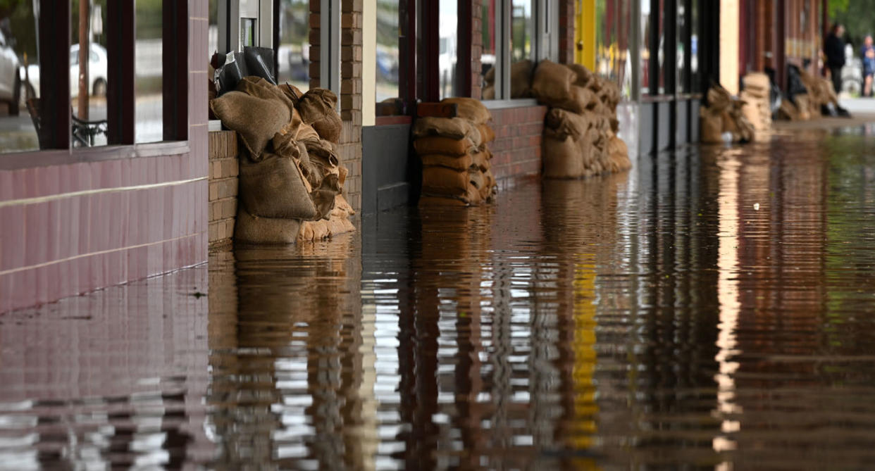 Sandbags in floodwater along a strip of businesses in Rochester, Victoria