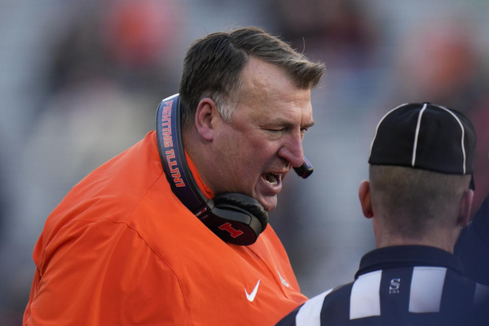 Illinois head coach Bret Bielema, left, talks to referees during the first half of an NCAA college football game against Northwestern, Saturday, Nov. 25, 2023, in Champaign, Ill. (AP Photo/Erin Hooley)