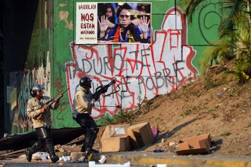 Miembros de la Policía Nacional disparan contra manifestantes en contra del gobierno en Caracas, el 21 de abril de 2014. (AFP | Carlos Becerra)