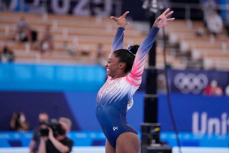 Simone Biles smiles after she finishes her beam routine during the balance beam final. 