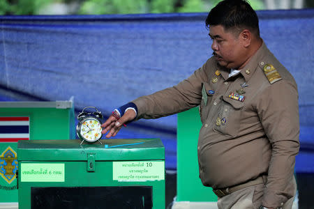 An official checks the time at a polling station, ahead of voting in the general election in Bangkok, Thailand, March 24, 2019. REUTERS/Athit Perawongmetha