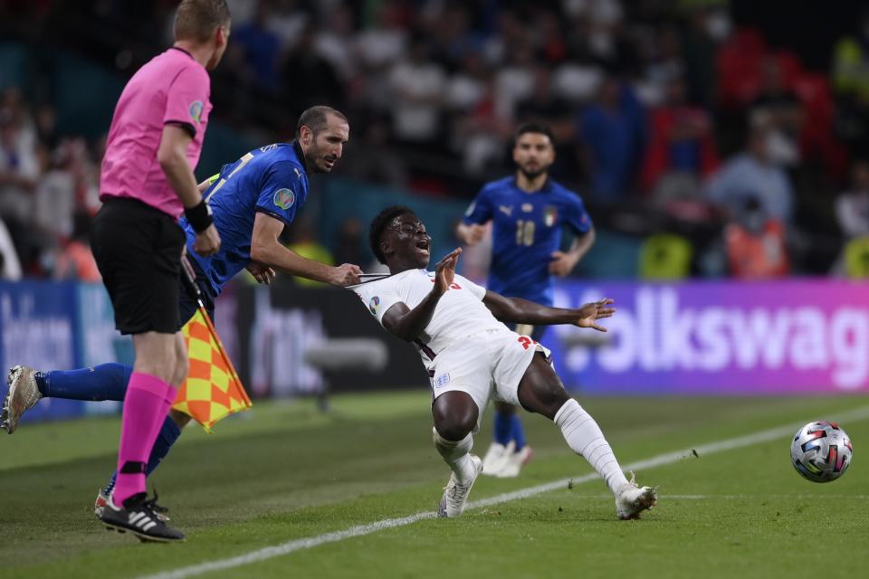 El italiano Giorgio Chiellini (izquierda) detiene al inglés Bukayo Saka durante la final de la Euro 2020, el domingo 11 de julio de 2021, en Londres. (Laurence Griffiths/Pool vía AP)