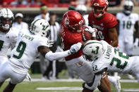 Louisville running back Trevion Cooley (23) is tackled by South Florida defensive back Aamaris Brown (9), and defensive back Mekhi LaPointe (22) during the second half of an NCAA college football game in Louisville, Ky., Saturday, Sept. 24, 2022. Louisville won 41-3. (AP Photo/Timothy D. Easley)