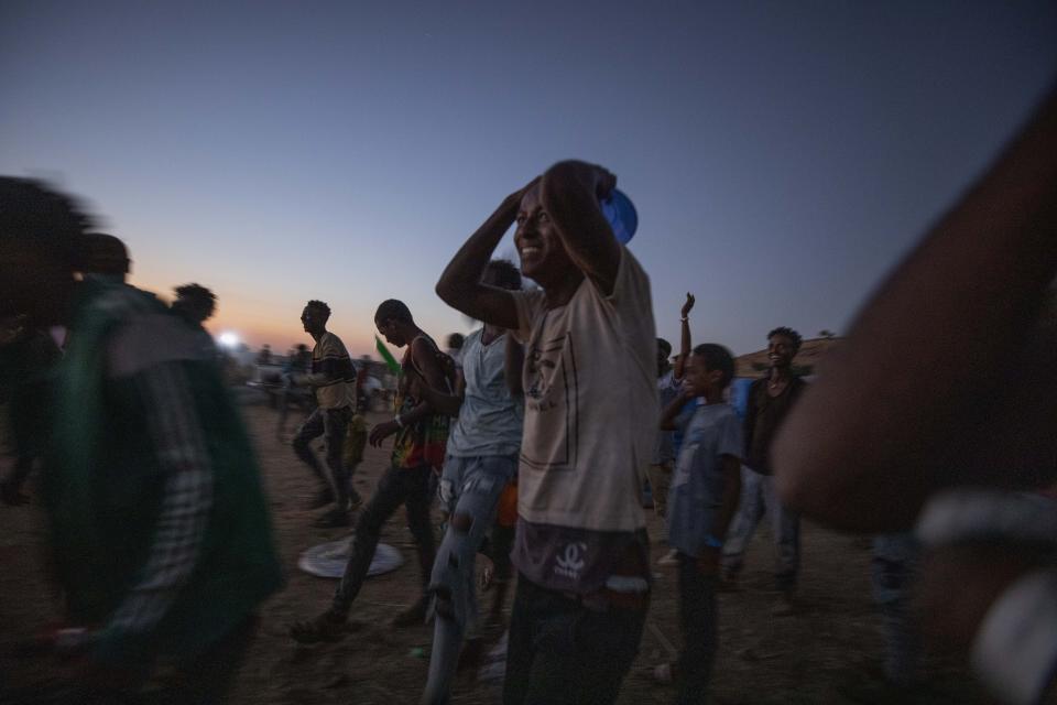 Tigray men who fled the conflict in Ethiopia's Tigray region, run to recieve cooked rice from charity organization Muslim Aid, at Umm Rakouba refugee camp in Qadarif, eastern Sudan, Friday, Nov. 27, 2020. Ethiopian Prime Minister Abiy Ahmed again ruled out dialogue with the leaders of the defiant Tigray region Friday but said he was willing to speak to representatives "operating legally" there during a meeting with three African Union special envoys trying to end the deadly conflict between federal troops and the region's forces. (AP Photo/Nariman El-Mofty)