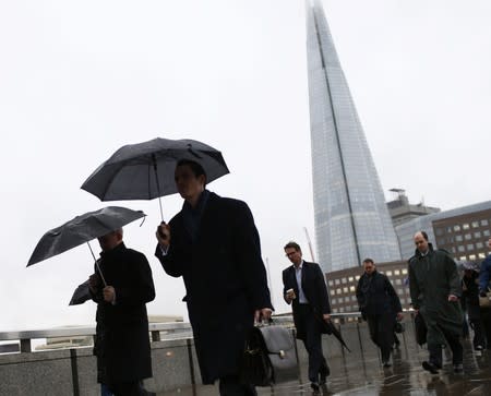 The Shard is seen as workers cross London Bridge in London