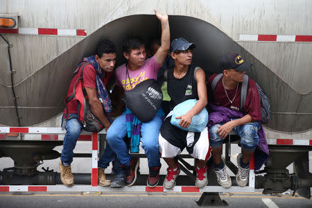 Honduran migrants, part of a caravan trying to reach the U.S., are pictured on a truck during a new leg of their travel in Zacapa, Guatemala October 17, 2018. REUTERS/Edgard Garrido