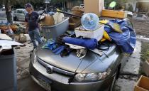 Chris Roberson stands next to his car where possessions were placed on the hood to dry out in Longmont, Colorado September 16, 2013. (REUTERS/Rick Wilking)