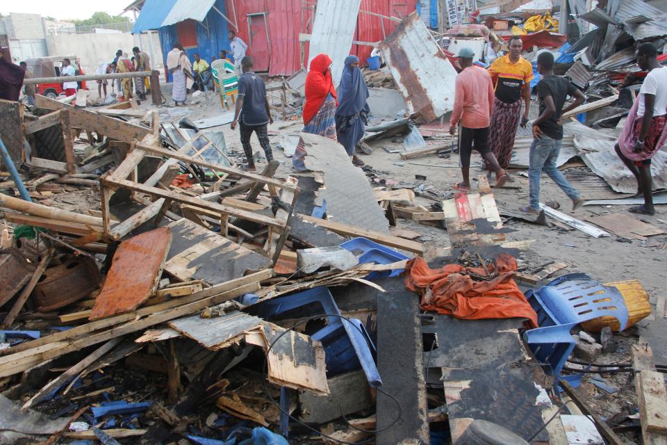 People look at destroyed shops in Mogadishu's Lido beach, Somalia, Saturday, April, 23, 2022, after a bomb blast by Somaliaâ€™s Islamic extremist rebels hit a popular seaside restaurant killing at least six people. Ambulance service officials say the explosion occurred Friday evening when many patrons gathered for an Iftar meal to break the Ramadan fast.