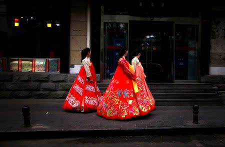 Workers from a nearby North Korean restaurant walk along a footpath wearing traditional costumes in central Beijing June 18, 2012. REUTERS/David Gray/File Photo