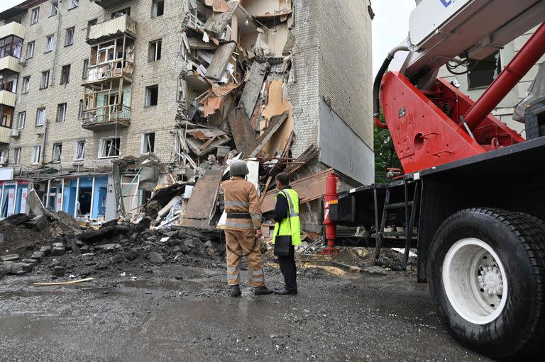 Rescatistas ucranianos trabajan en el exterior de un edificio parcialmente destruido tras un ataque de misiles rusos en Kharkiv el 11 de julio de 2022, en medio de la invasión militar rusa lanzada sobre Ucrania.