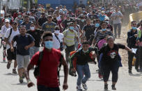 Migrants attempt to cross the border from Corinto, Honduras, into Corinto, Guatemala, Thursday, Oct. 1, 2020. Hundreds of migrants walked from San Pedro Sula, Honduras to the Guatemala border, testing a well-trod migration route now in times of the new coronavirus. (AP Photo)