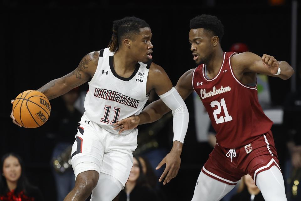 Charleston's Jaylon Scott (21) defends against Northeastern's Jahmyl Telfort (11) during the first half of an NCAA college basketball game, Saturday, Jan. 21, 2023, in Boston. (AP Photo/Michael Dwyer)