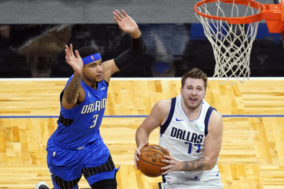 Dallas Mavericks guard Luka Doncic (77) goes past Orlando Magic forward Chuma Okeke (3) for a basket during the first half of an NBA basketball game, Monday, March 1, 2021, in Orlando, Fla. (AP Photo/John Raoux)