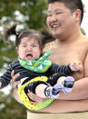 A crying baby is carried by a student sumo wrestler during the "Baby-cry Sumo" competition at Tokyo's Sensoji temple on April 30, 2011. Some 50 babies aged under one participated in the annual baby crying contest. Japanese parents believe that sumo wrestlers can help make babies cry out a wish to grow up with good health. AFP PHOTO/Yoshikazu TSUNO