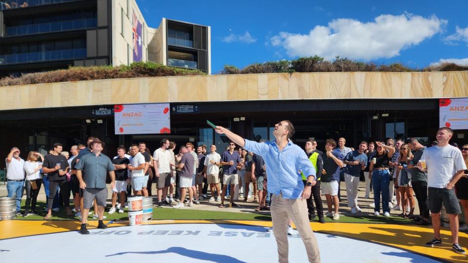 A man uses a paddle to throw two coins into the air