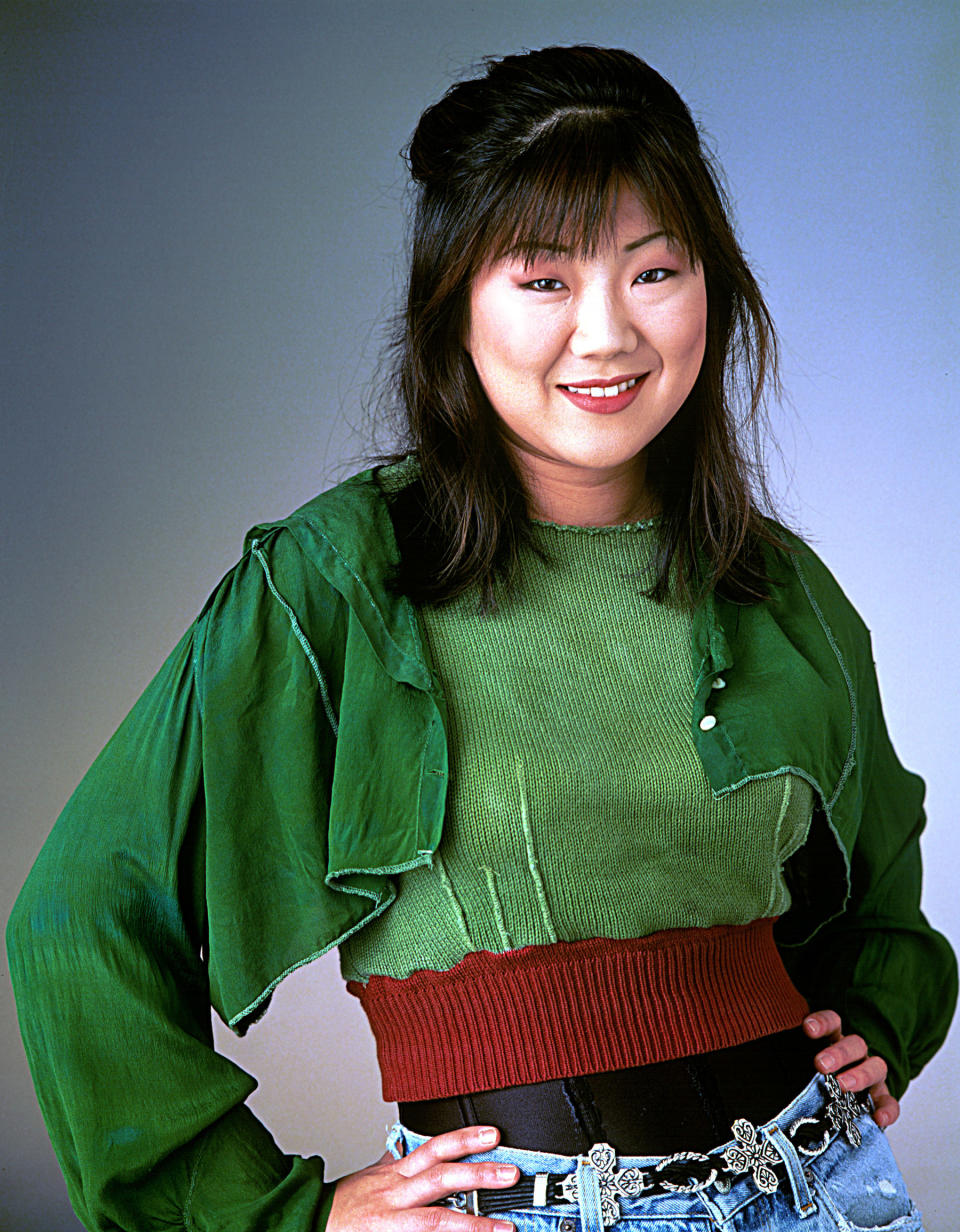 Margaret Cho smiling with her hands on her hips