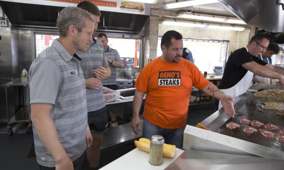 Newcastle’s Dave Walder and Harrison Orr learning how to make a Philly cheesesteak at Geno’s Steaks