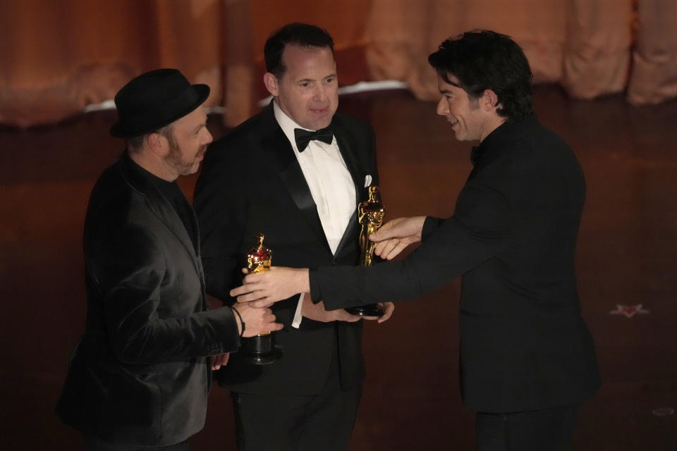 John Mulaney, derecha, entrega el premio a mejor sonido a Tarn Willers, izquierda, y Johnnie Burn por "The Zone of Interest" en los Oscar el domingo 10 de marzo de 2024, en el Teatro Dolby en Los Ángeles. (Foto AP/Chris Pizzello)