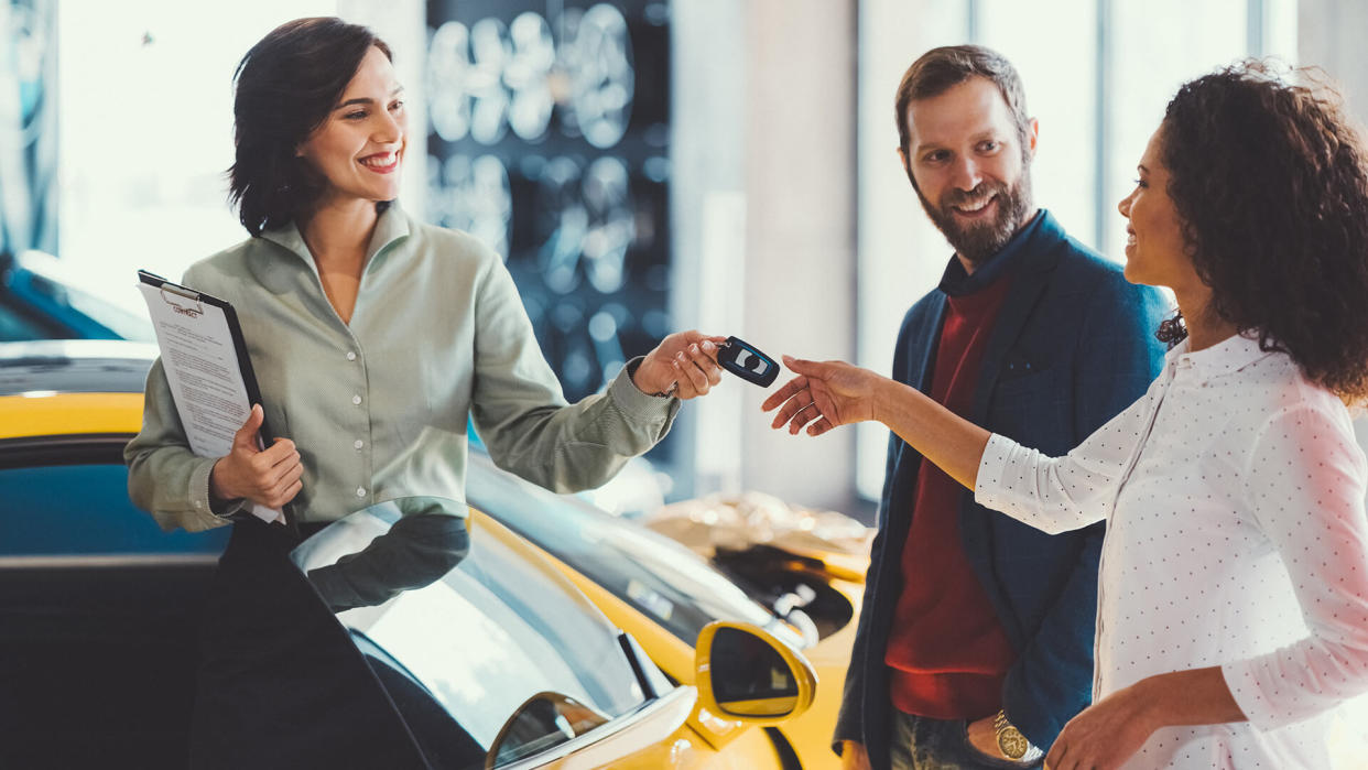 Young man surprising his wife with buying a new car.