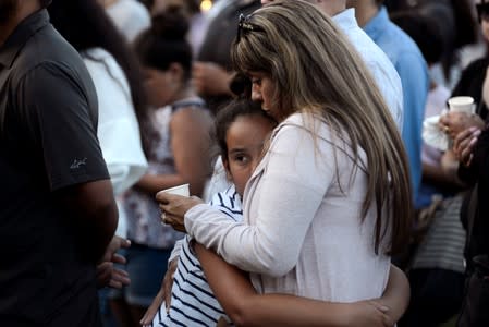 Patty Lopez hugs her daughter Pricilla (9) during a vigil outside of Gilroy City Hall for the victims of a mass shooting at the Gilroy Garlic Festival